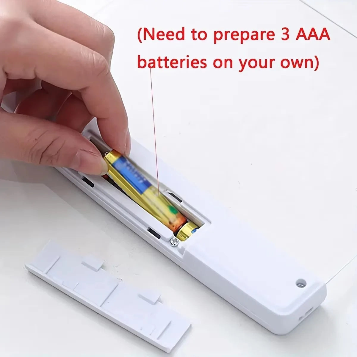 Hand inserting batteries into a device with text indicating the need for 3 AAA batteries.