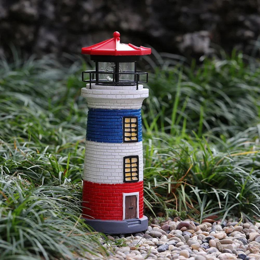 Decorative lighthouse with red, white, and blue colors on a grassy background