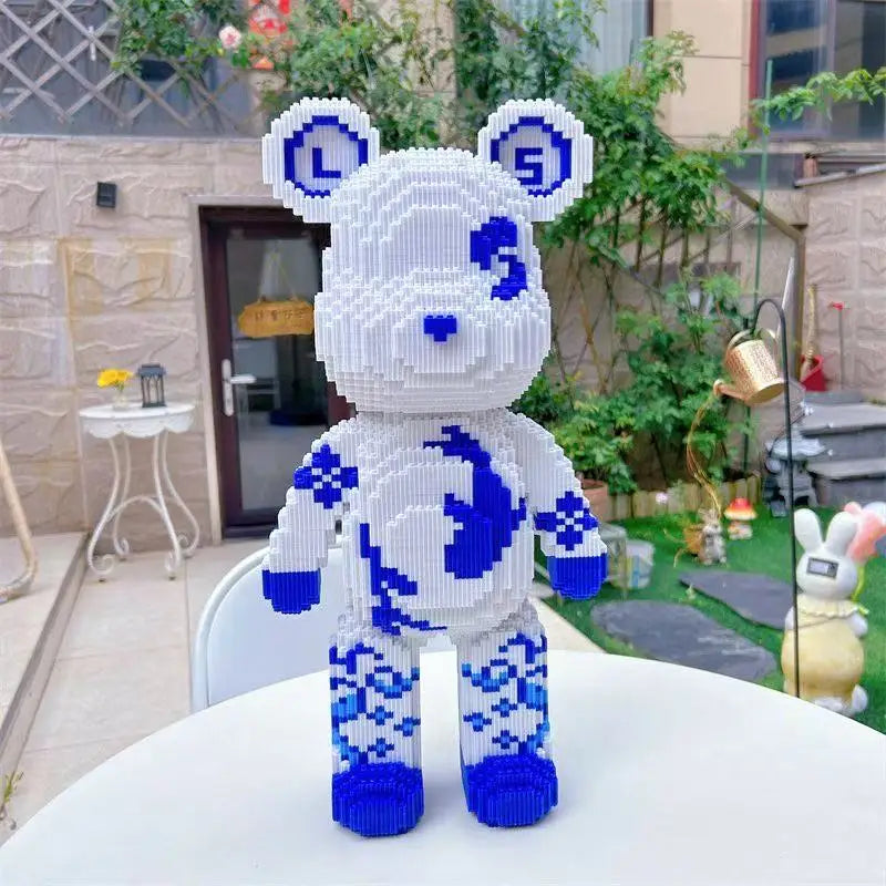 Toy lego compatible building block puzzle bear made of interlocking bricks in white and blue on a table outdoors.
