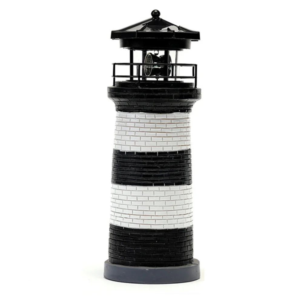 Model lighthouse with black and white striped design on a white background