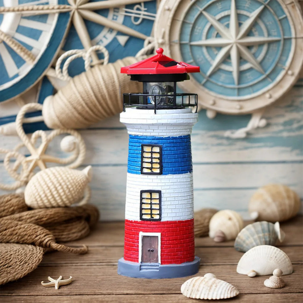 Decorative lighthouse with red, white, and blue colors on a wooden surface with seashells and nautical decorations.