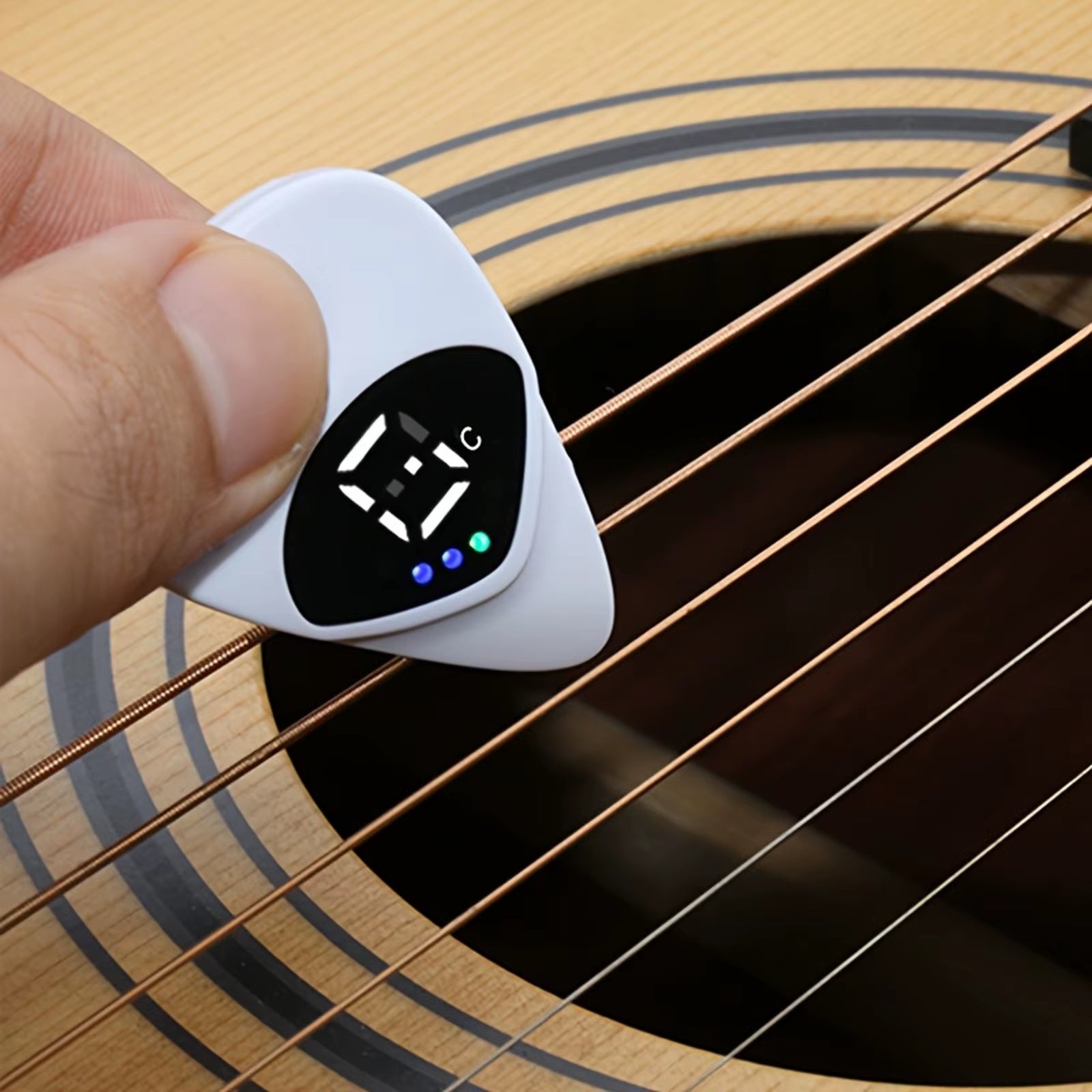 Magic Guitar Pick portable tuner displaying LED pitch indicators for perfect tuning.