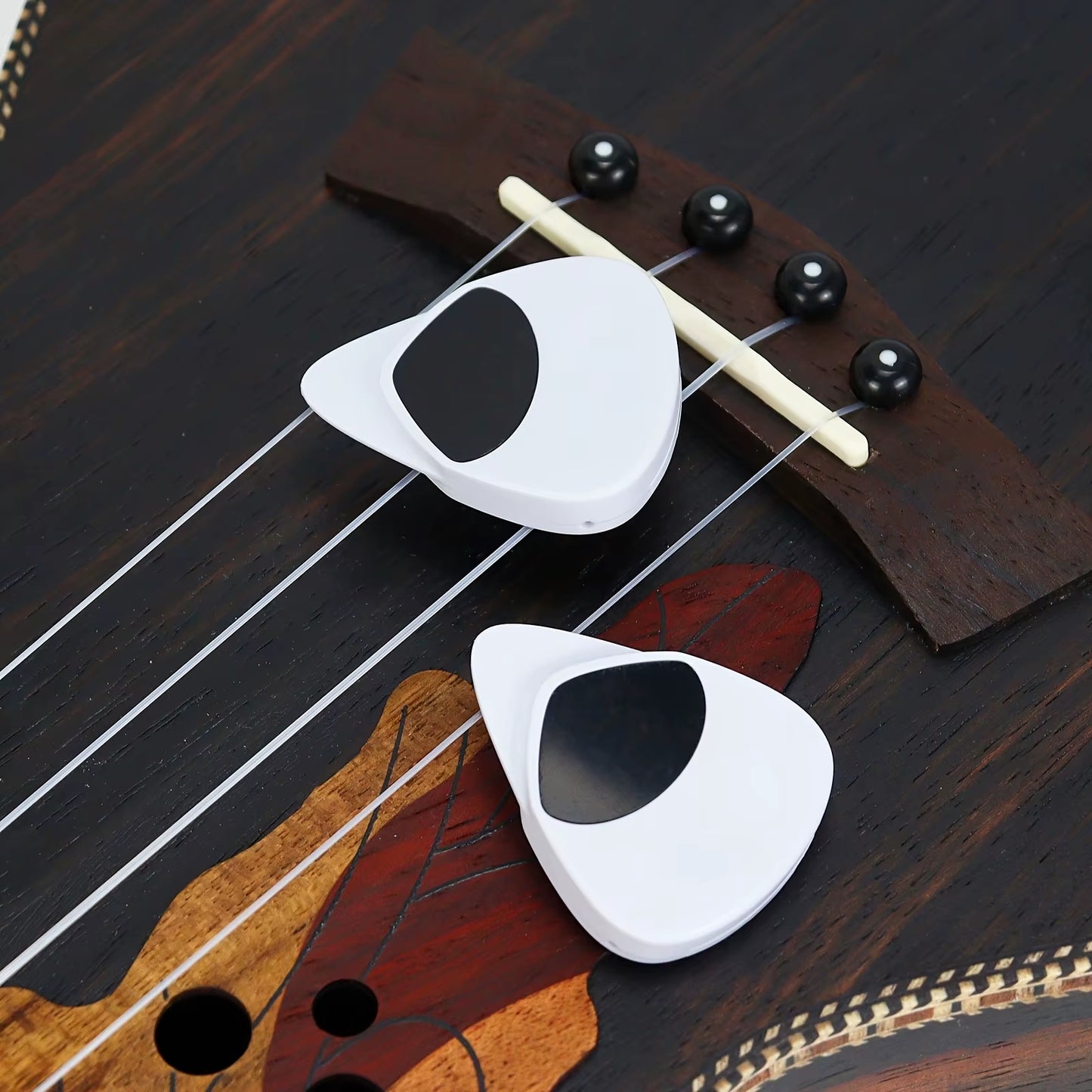 Close-up of the digital tuner interface built into the ergonomic guitar pick design.