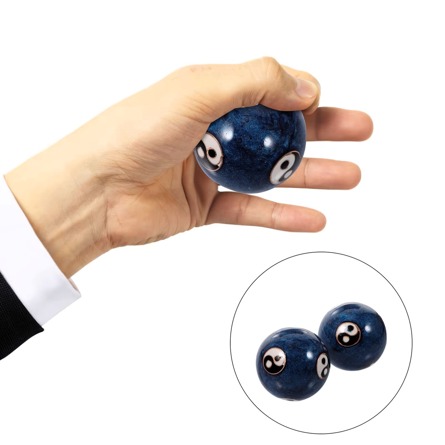 A hand holds a small glossy dark blue baoding ball with white and black eye motifs, with a circular inset showing two similar balls on a white background.