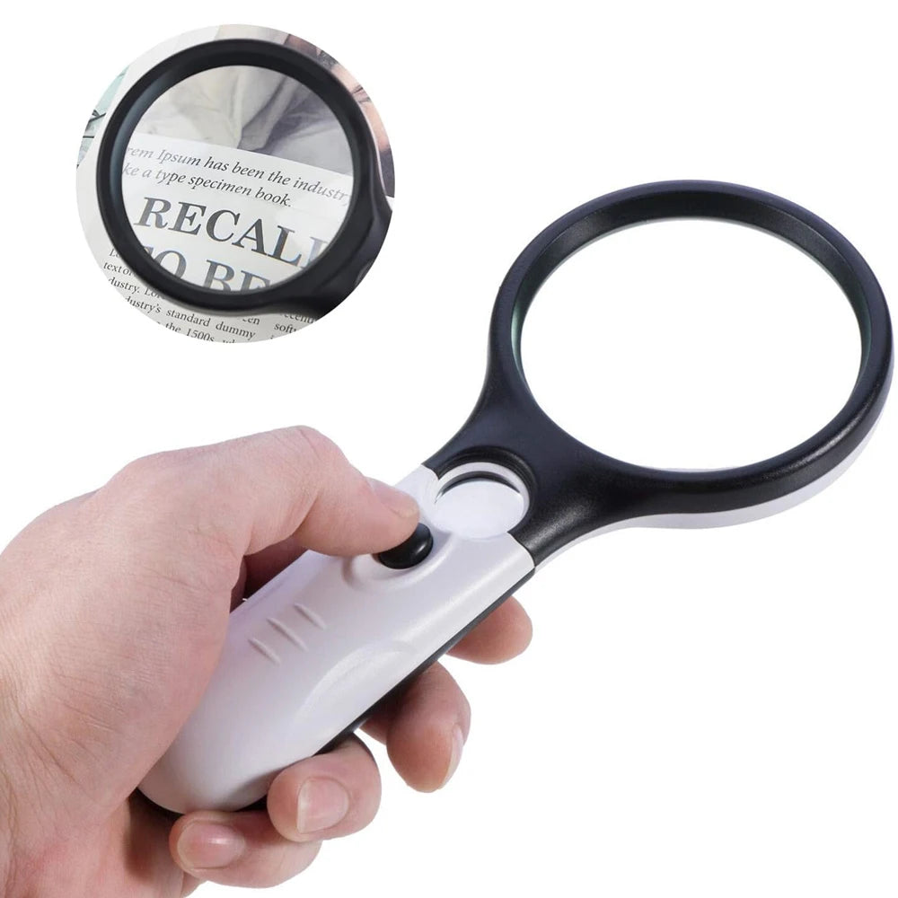 Hand holding a magnifying glass over a piece of paper with text.