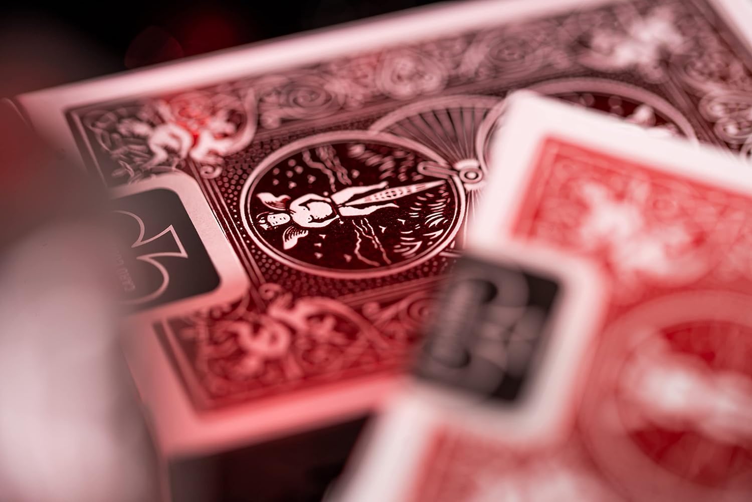 Blurred image of Metalluxe Red Playing Card decks sat atop each other for display.