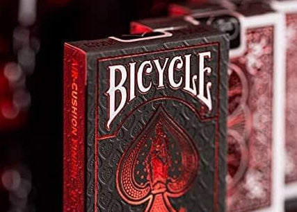 Multiple decks of the Metalluxe Red Playing Cards Crimson Foil Back Edition, featuring one displaying the front of the deck and others showing the backside.