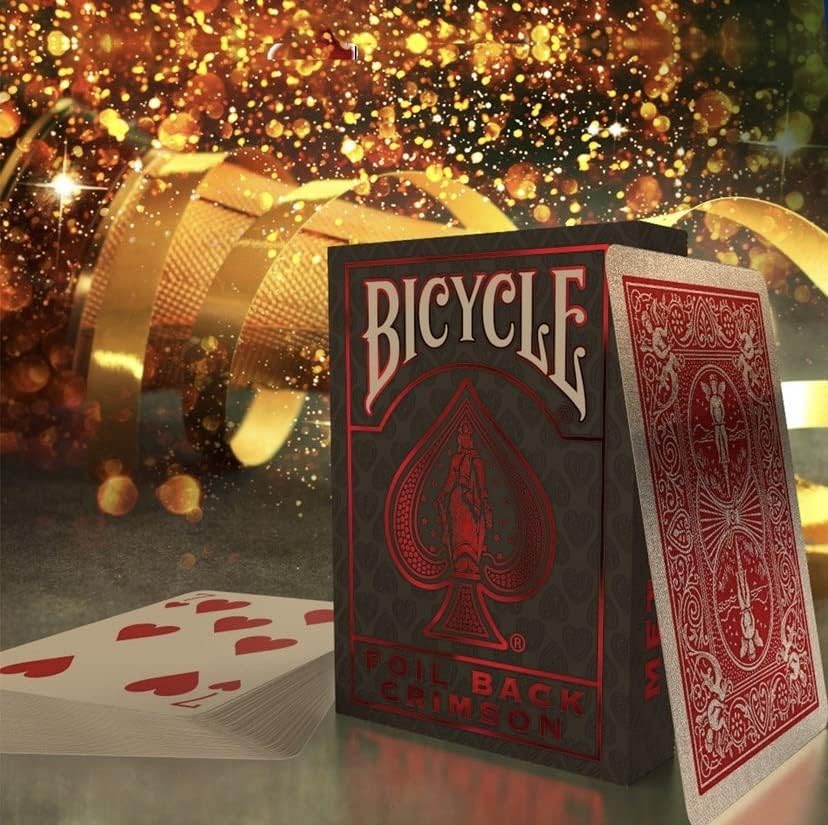 One deck of Metalluxe Red Playing Cards Crimson Foil Back on display with single cards next to it showing both sides of the playing cards and confetti in the background.
