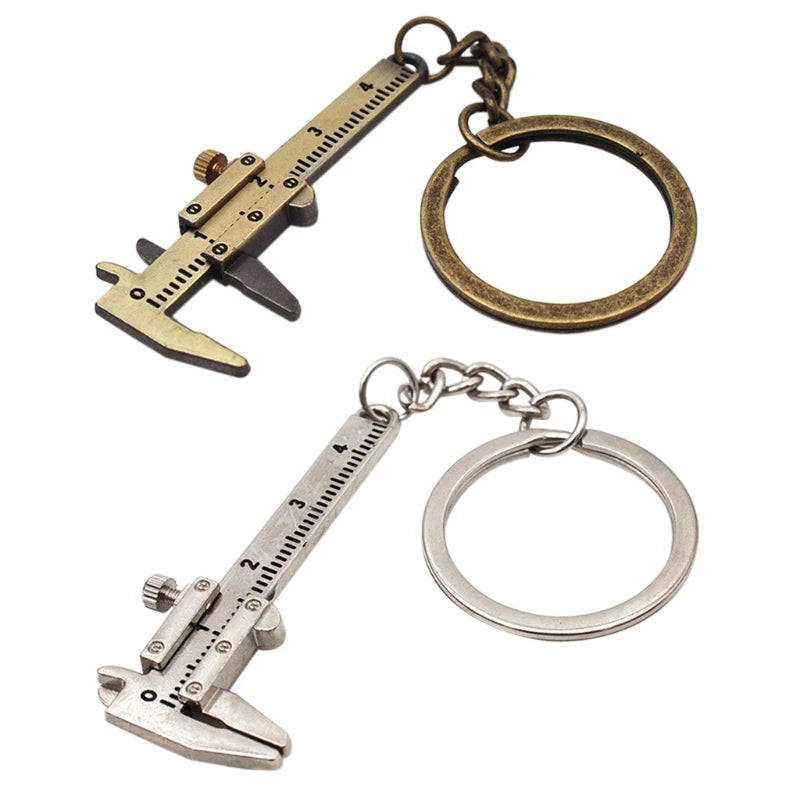 Two caliper-shaped keychains, one brass and one silver, on a white background.