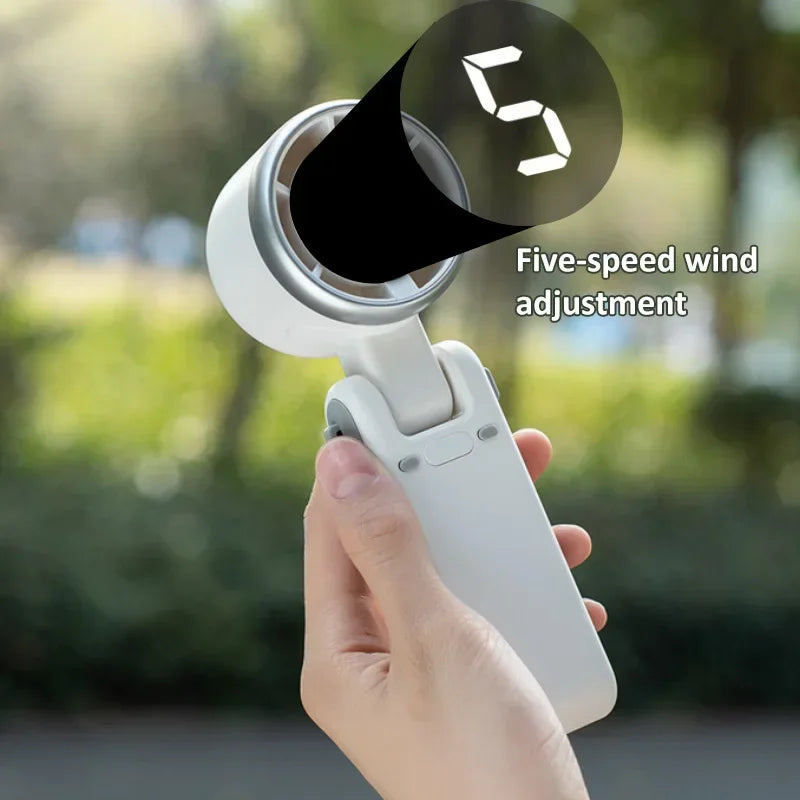 Hand holding a device with a five-speed wind adjustment feature, outdoors.
