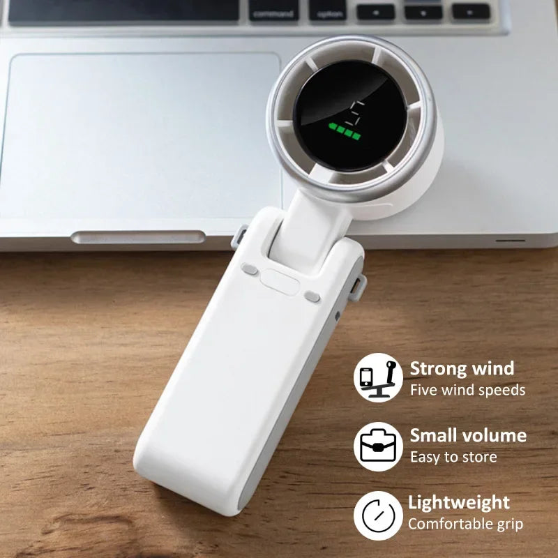 White handheld fan on a wooden surface with laptop in the background