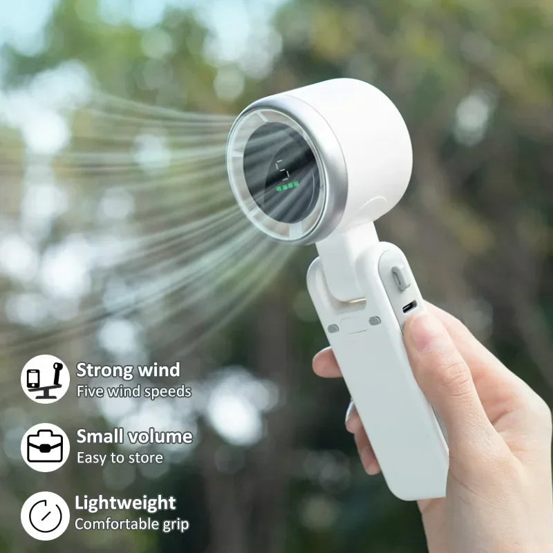 Handheld fan being used outdoors with features highlighted on the screen.