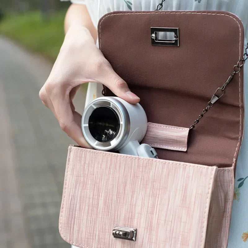 Person holding a brown handbag with a pink interior, containing a white container.