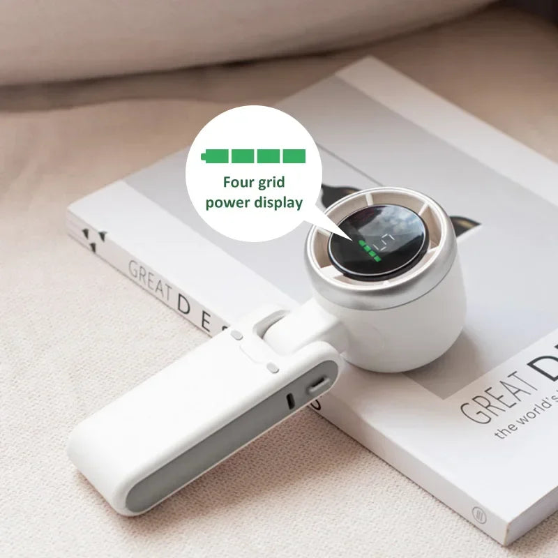 White electronic hand fan with power display on a book