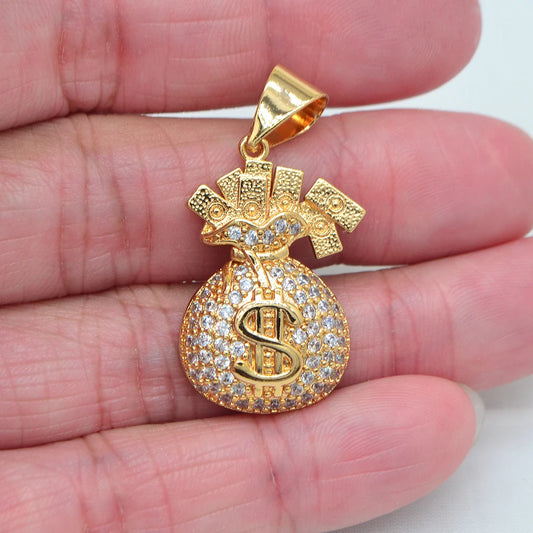 Gold pendant with a dollar sign design held between fingers