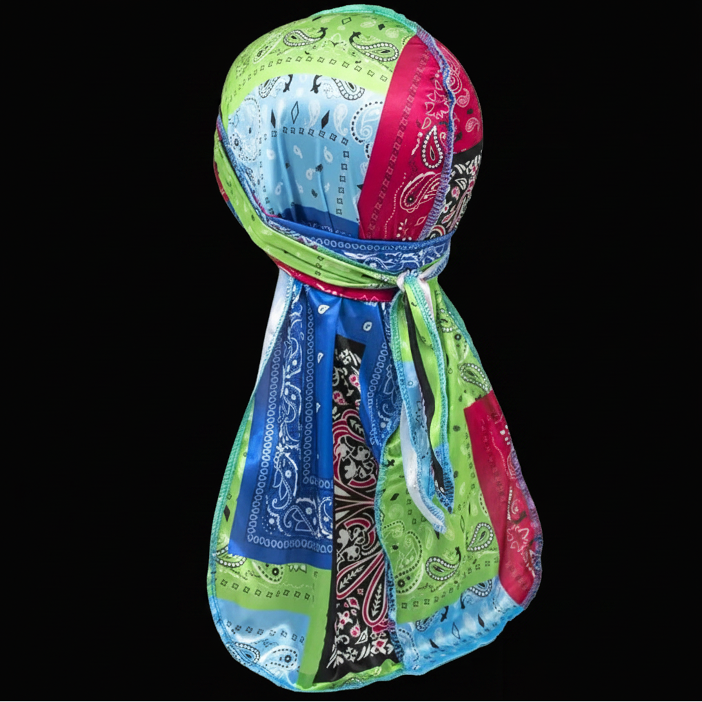 A multicolor patchwork bandana durag wave cap headscarf, featuring various paisley and floral patterns in green, blue, pink, and black, displayed on a black background.