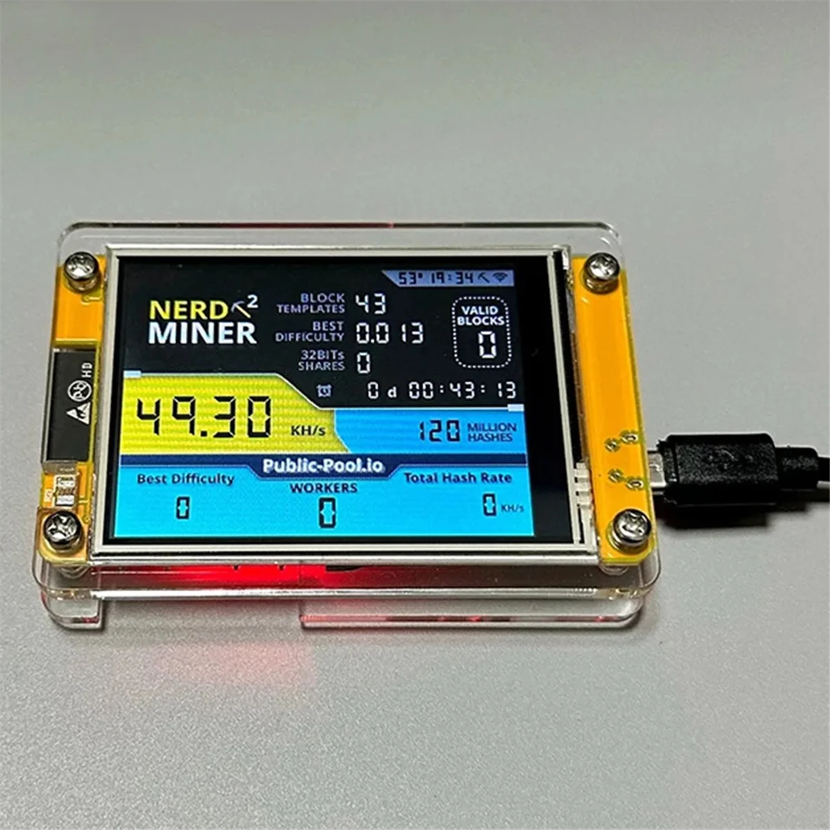 NerdMiner device with activated digital display mining on a grey background.