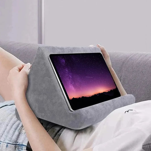 Person using a gray wedge pillow with a tablet on a couch