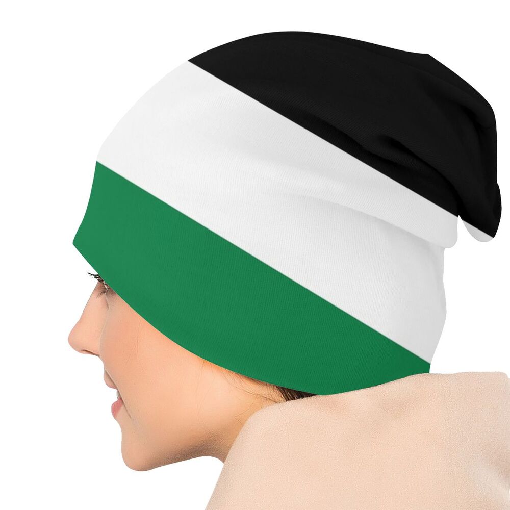 Person wearing a Palestinian flag Palestine Gaza skullie knitted ski cap headwear skull-cap in the black, white, and green and red from the Palestinian flag beanie skull-cap on a white background.