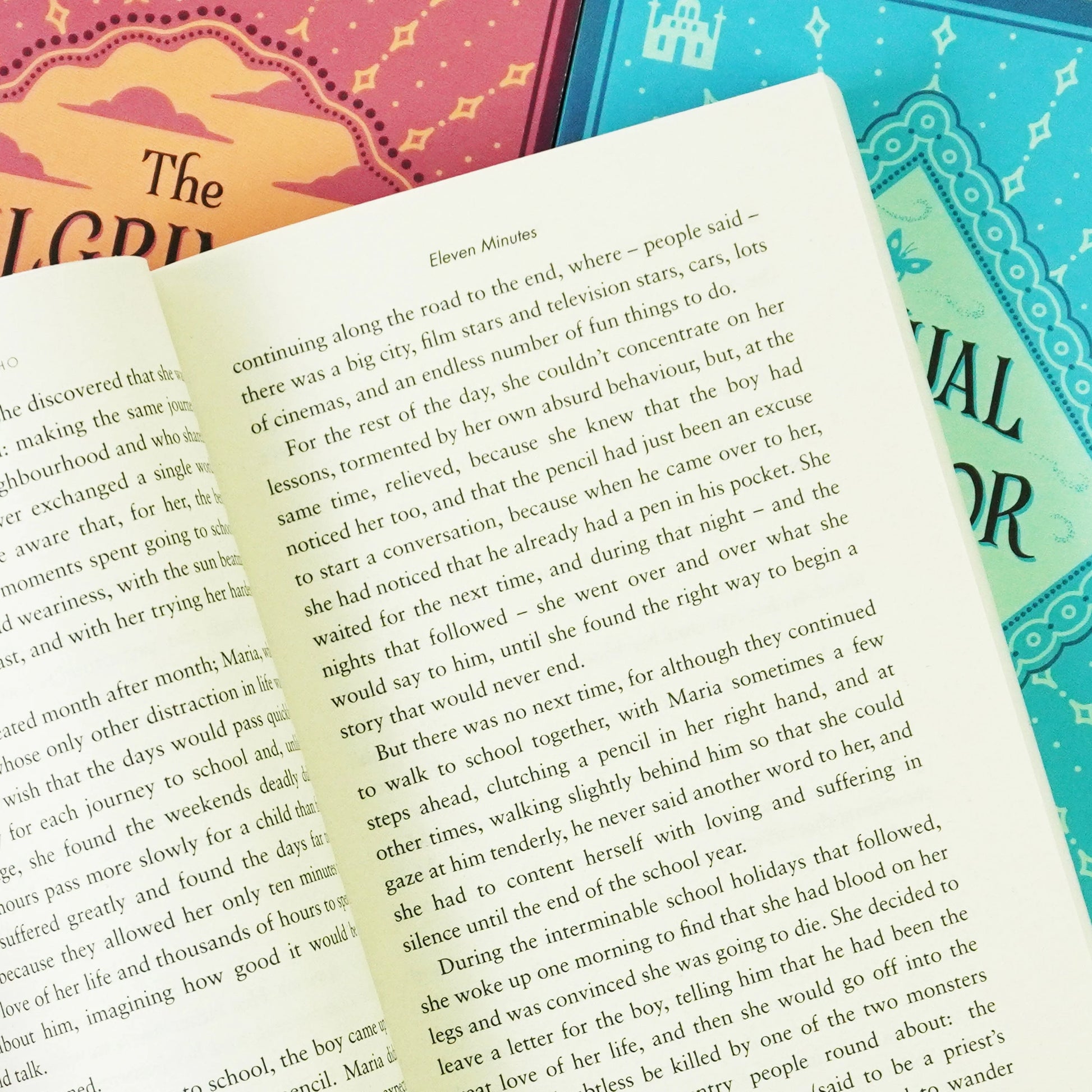Open book page from the 'Paulo Coelho Book Box-Set: Classic Deluxe Edition' showing other book covers in the background.