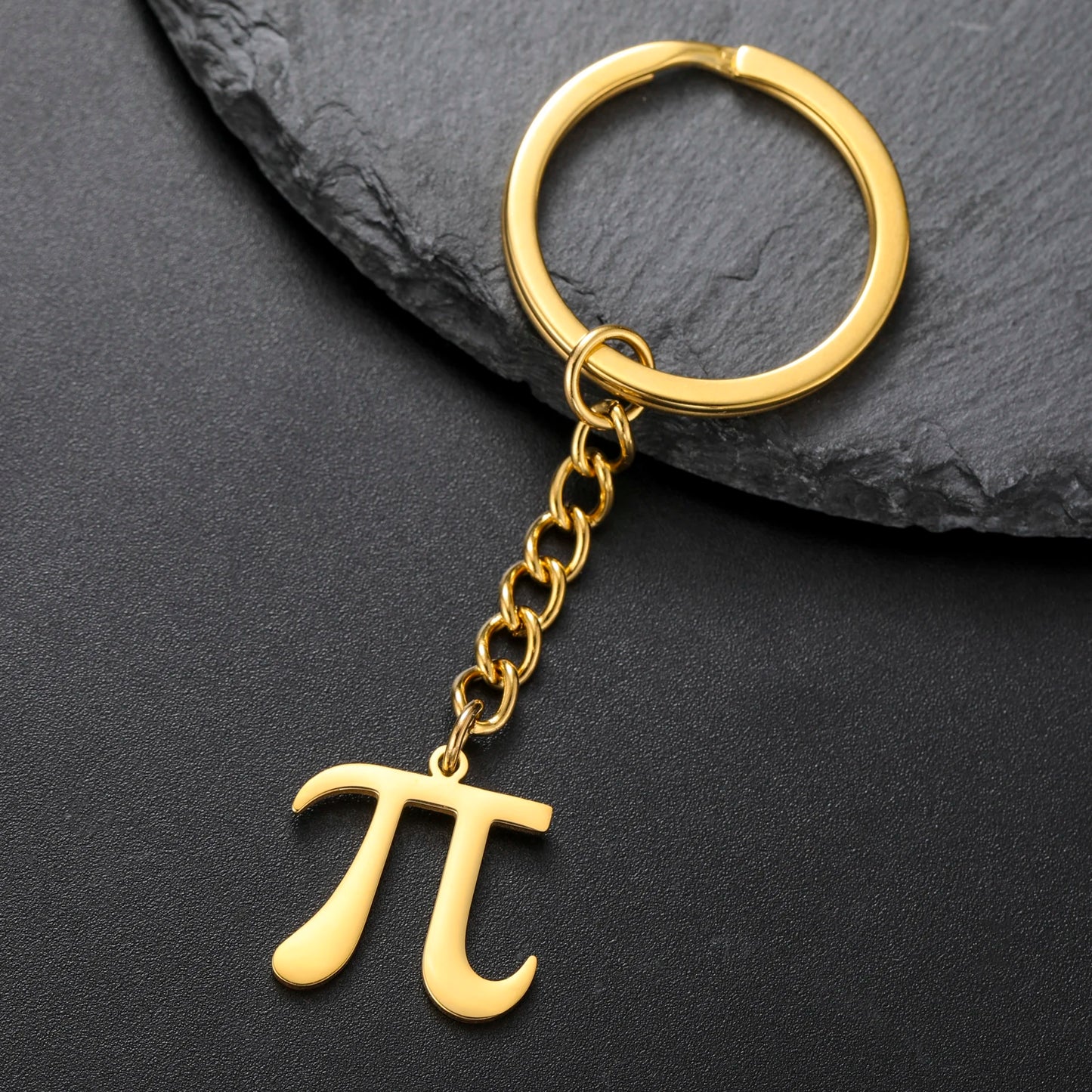 Gold keychain with pi symbol on a dark gray background