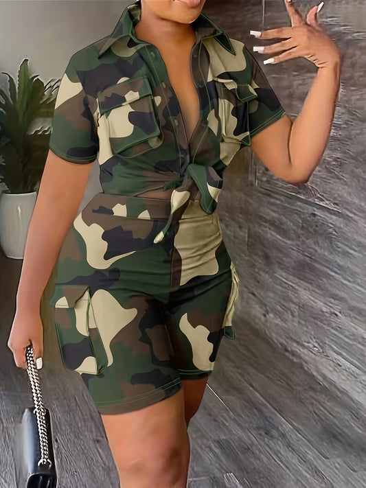 Woman wearing a camouflage outfit, holding a purse, with a plant and wooden floor in the background