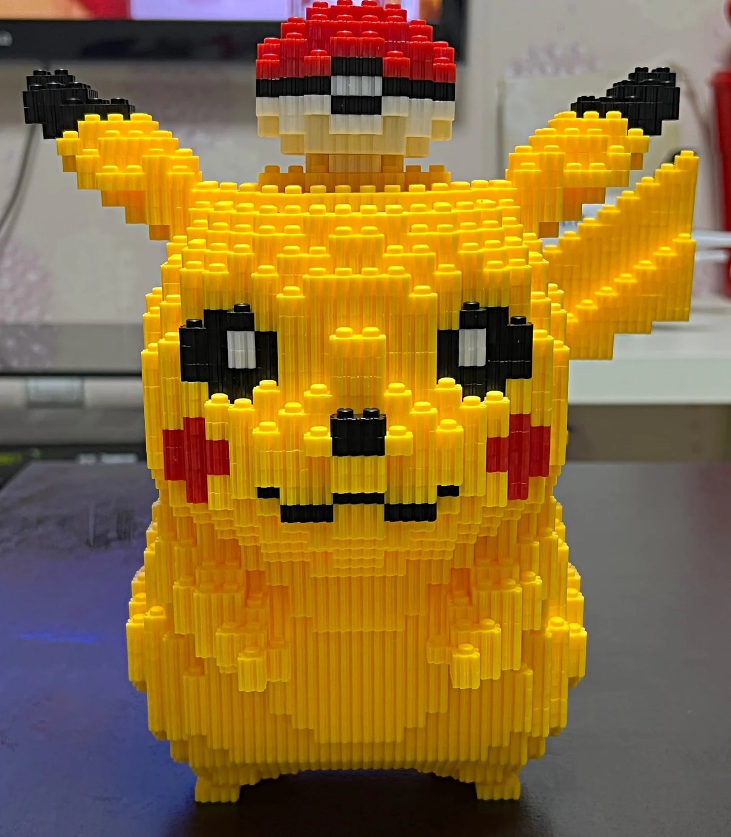Yellow Pikachu figure made of interlocking bricks on a dark surface.