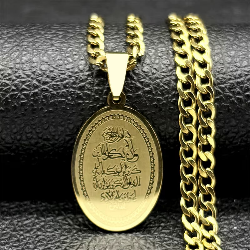 A gold-colored stainless steel pendant necklace with a chain, featuring an oval pendant with a Quranic verse inscription.