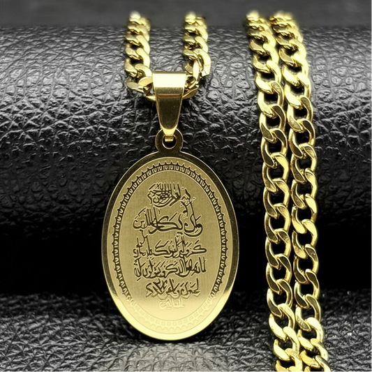 A gold-colored stainless steel pendant necklace with a chain, featuring an oval pendant with a Quranic verse inscription.