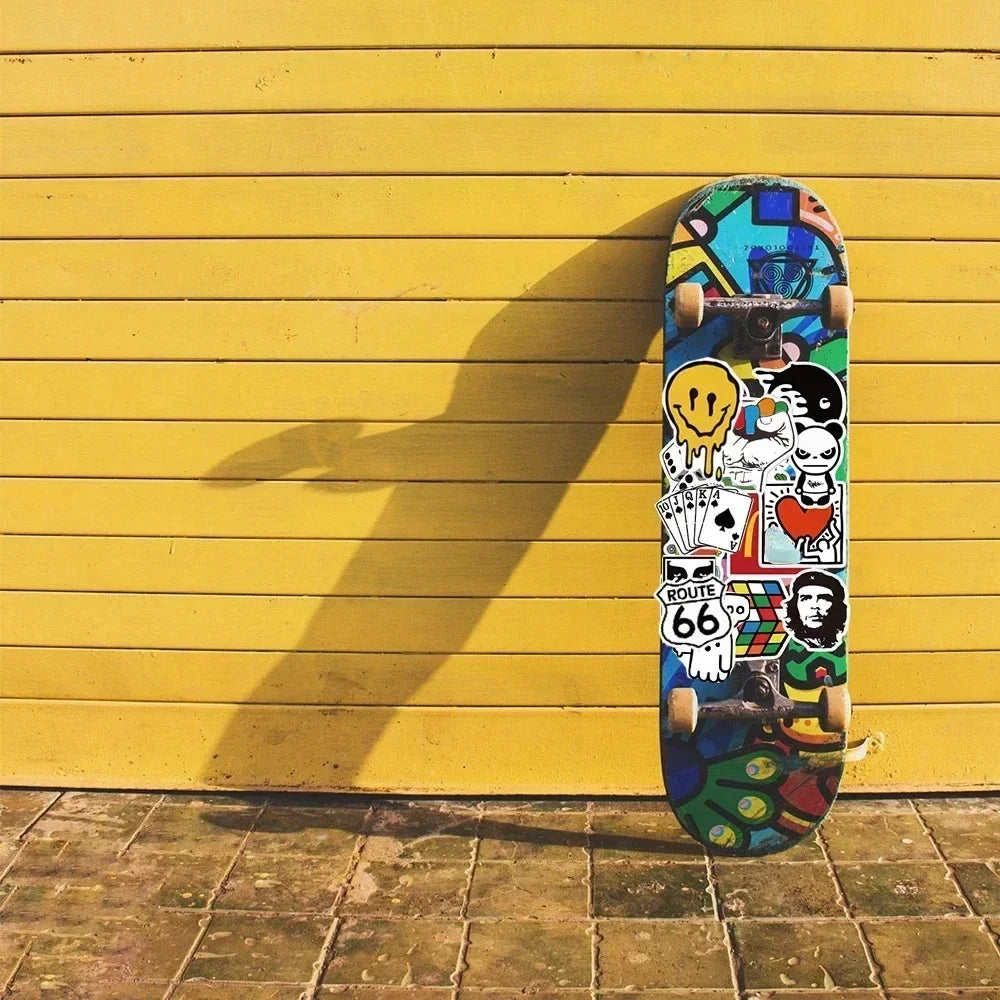 Colorful skateboard with stickers against a yellow wall