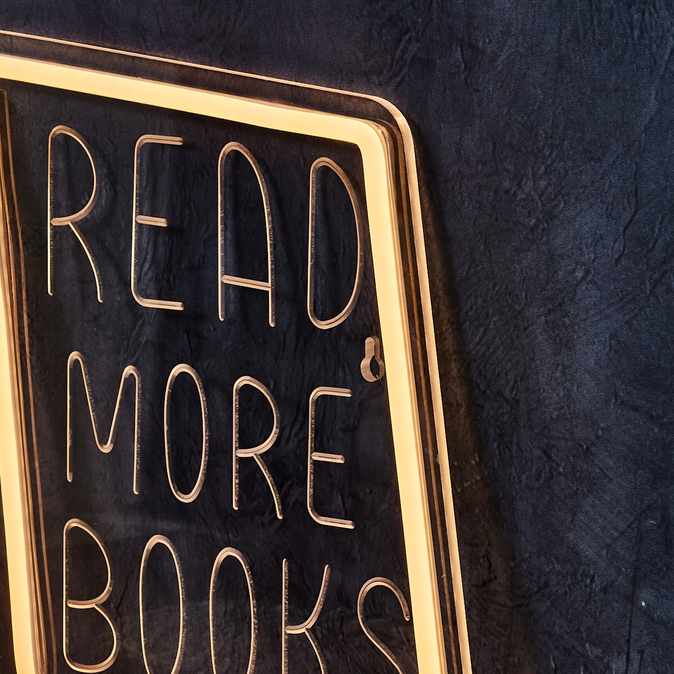 Decorative sign with 'READ MORE BOOKS' text on a dark background