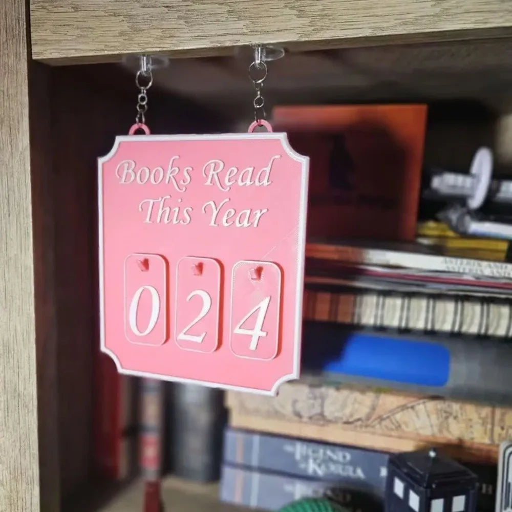 Pink plaque with 'Books Read This Year' and number '024' on a bookshelf.