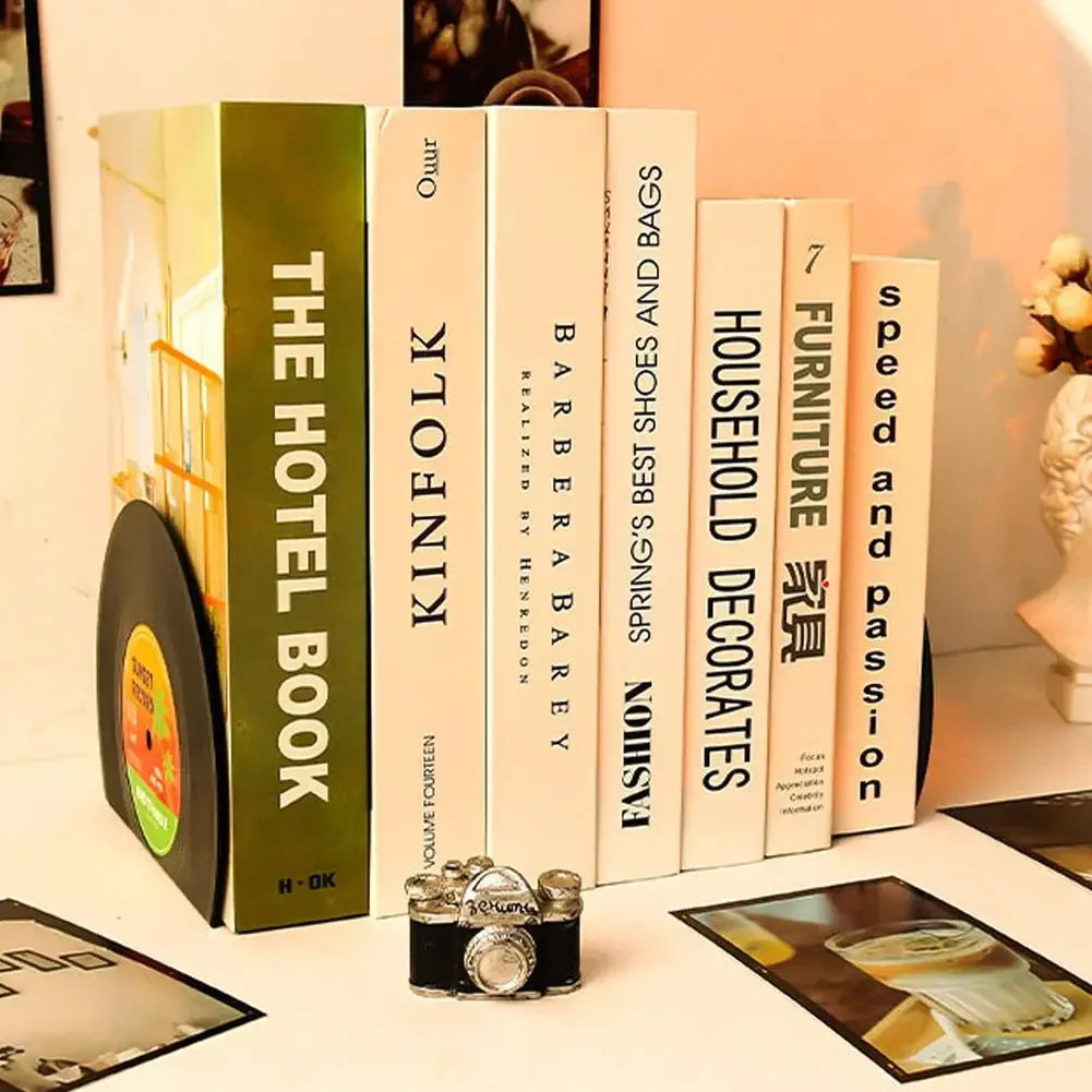 Stack of books between 'retro vinyl record bookends' holding various book titles on a surface and decorative items.