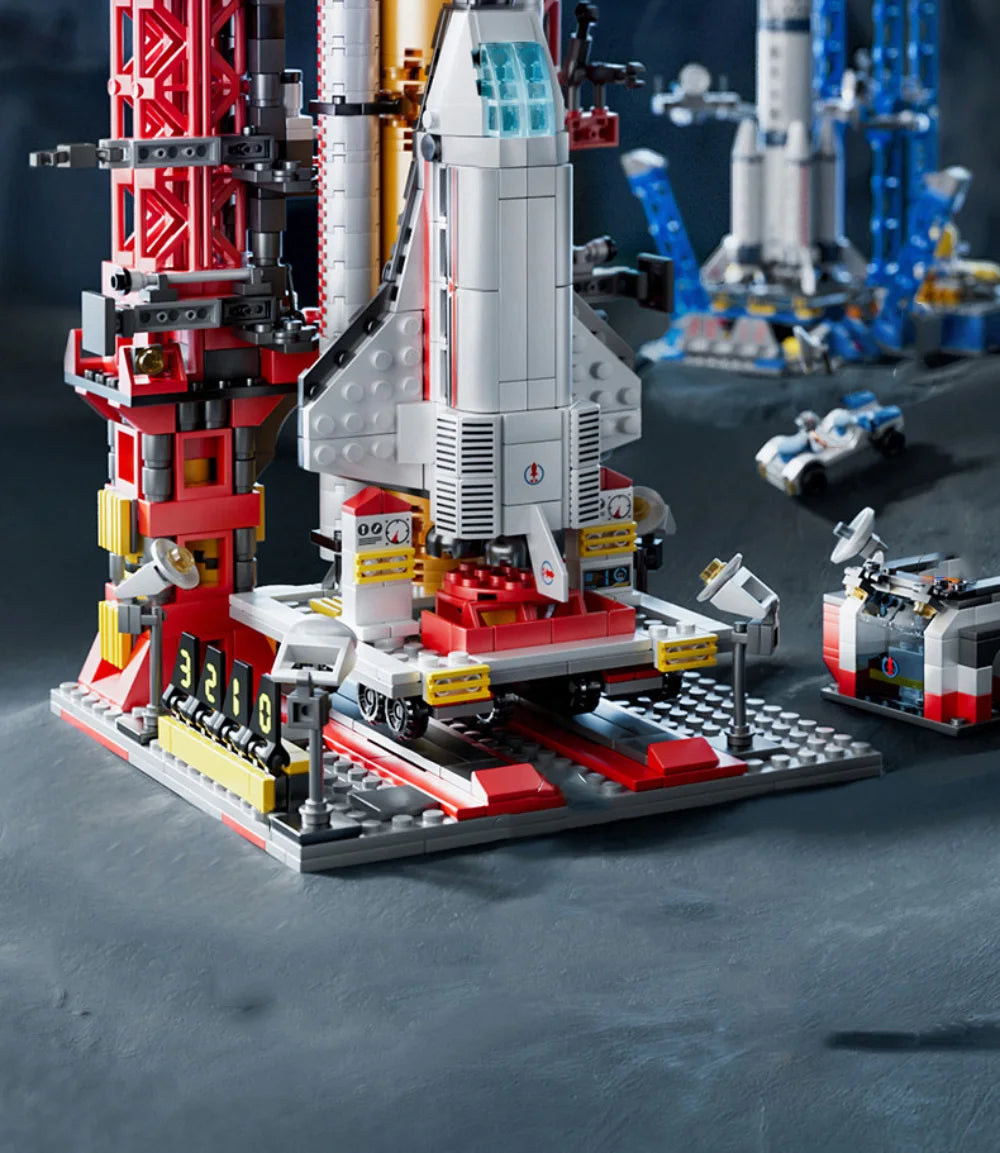 LEGO model of a space shuttle on a launch pad with other space-themed models in the background.