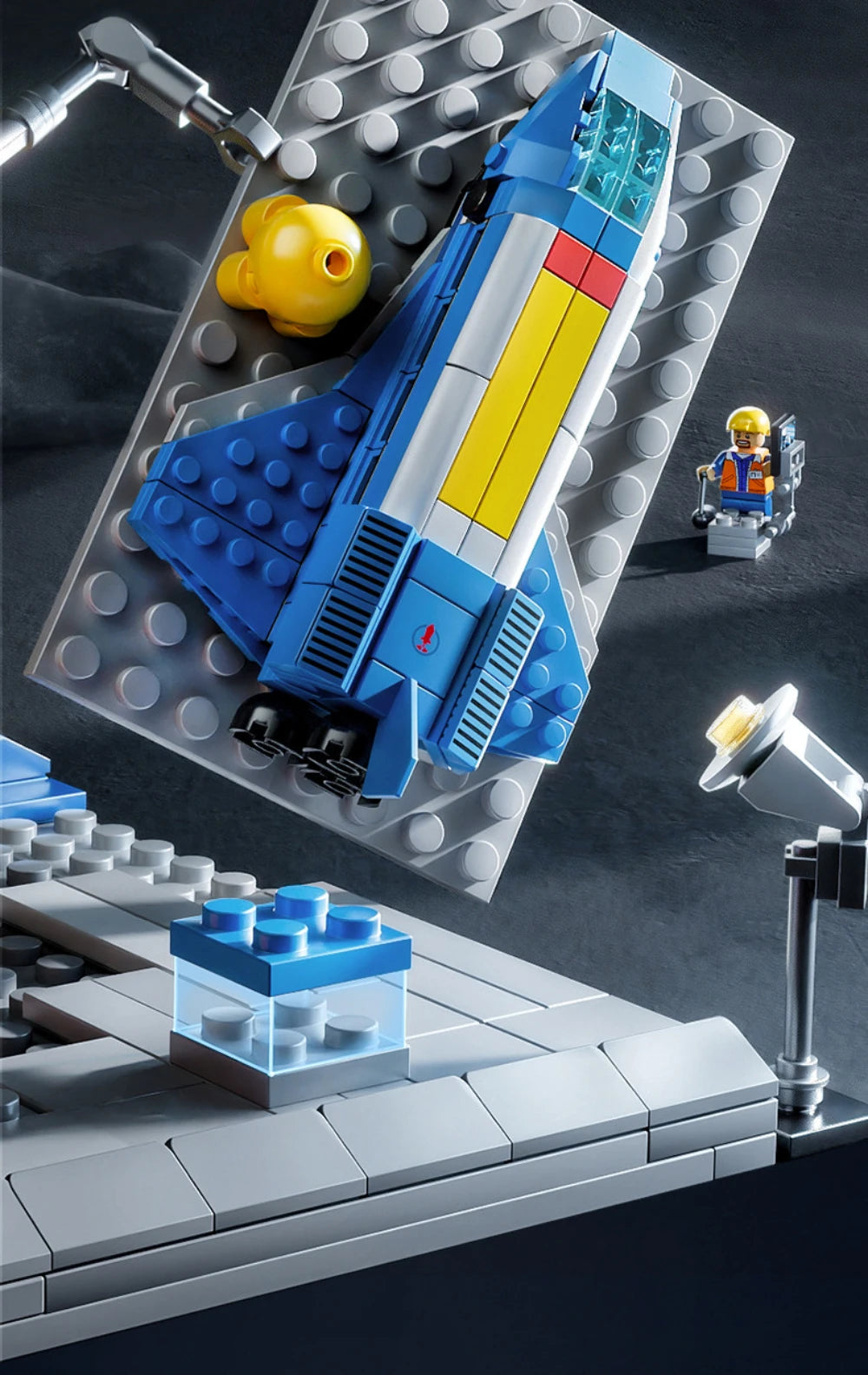 Toy spaceship model on a gray surface with tools and a small figure in the background