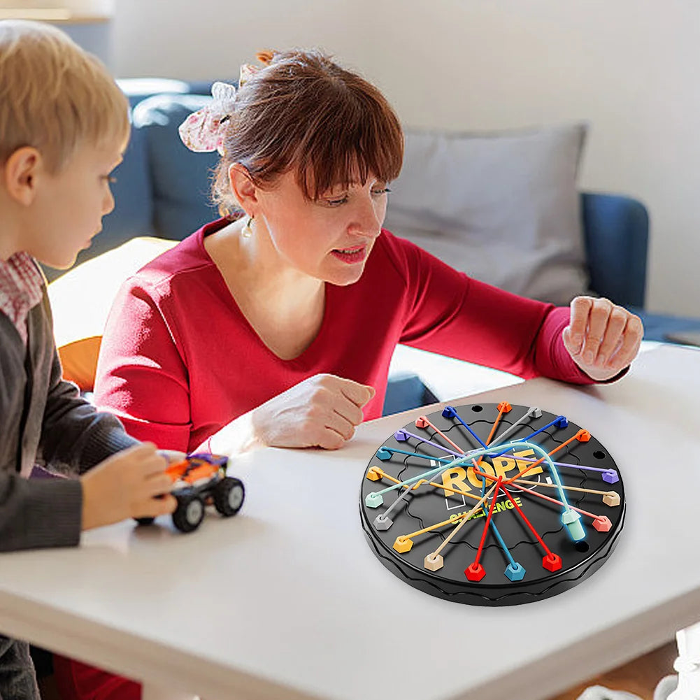 Woman and child playing a rope challenge board game together at a table.