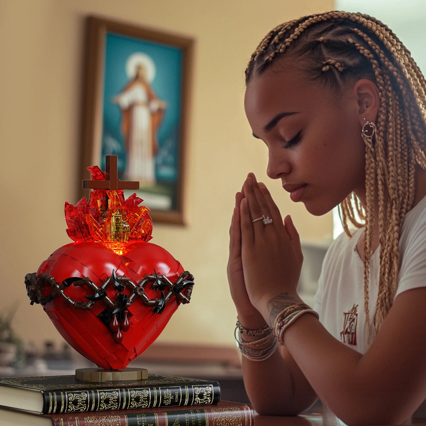 Woman praying with a red Sacred Heart statue in front of her