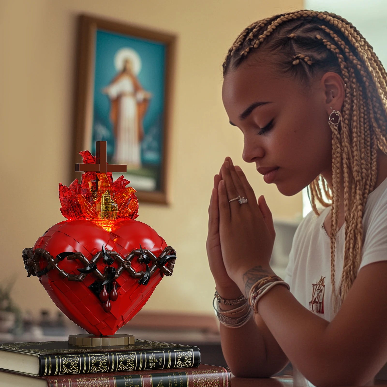 Woman praying with a red Sacred Heart statue in front of her