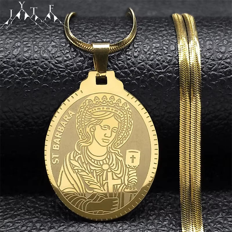 A gold-colored Saint Barbara pendant necklace with a flat chain, displayed on a dark background.