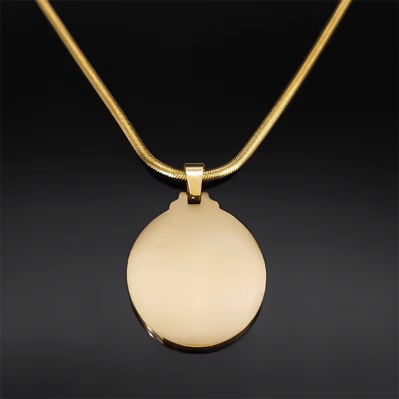 Back side of gold-colored Saint Barbara pendant necklace with a flat chain, displayed on a dark background.