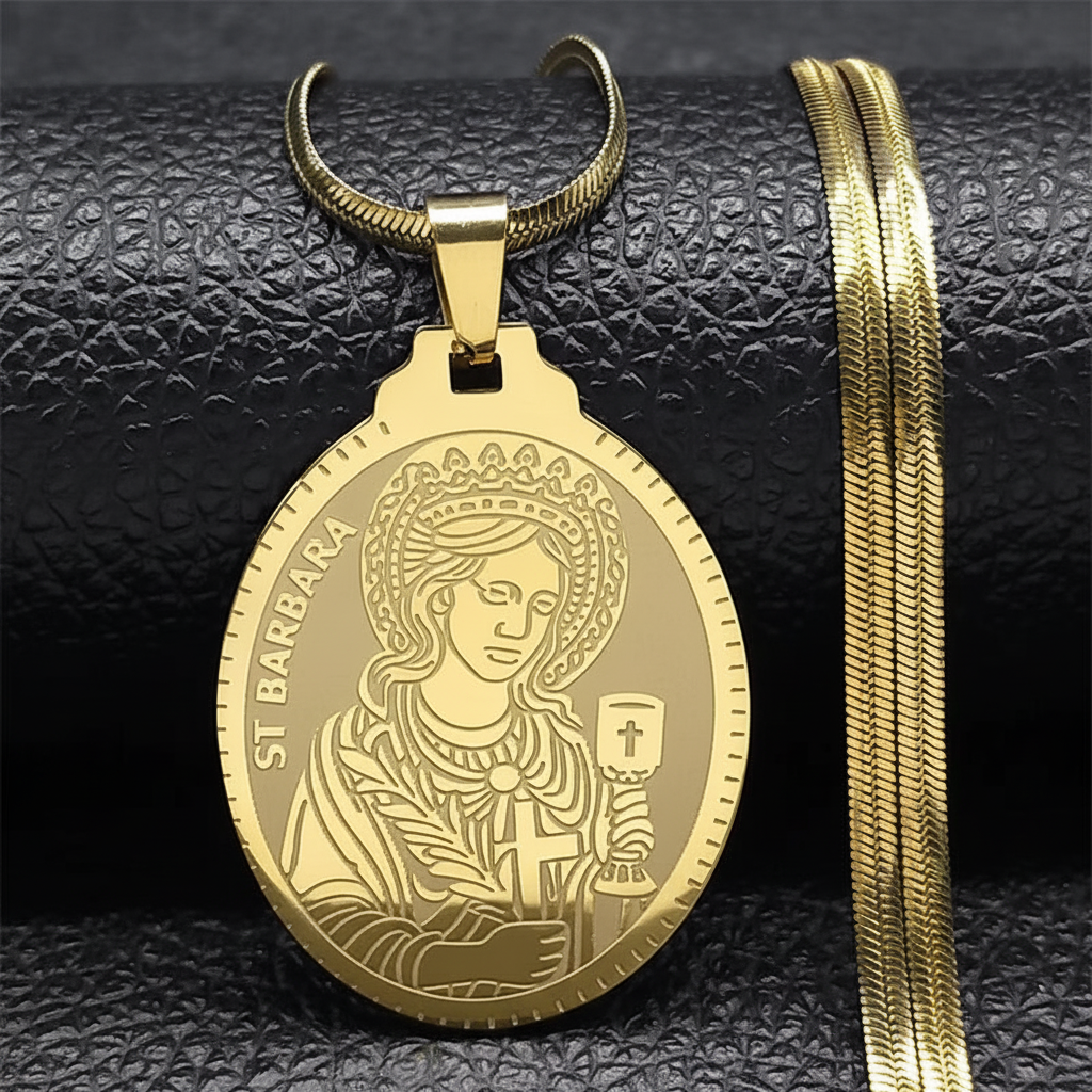 A gold-colored Saint Barbara pendant necklace with a flat chain, displayed on a dark background.