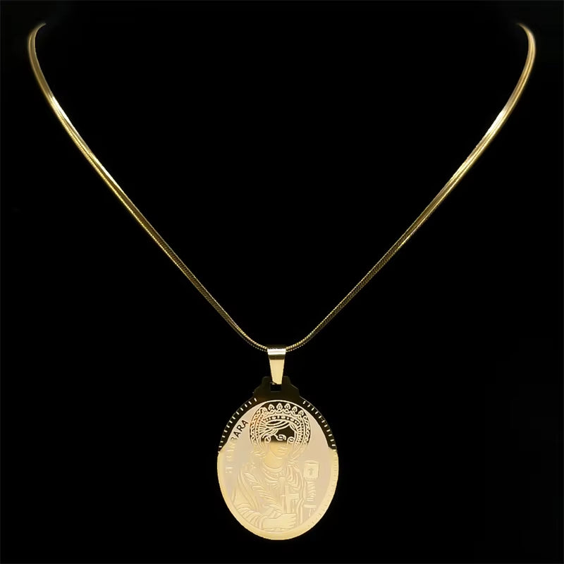 A gold-colored Saint Barbara pendant necklace with a flat chain, displayed on a dark silhouette clavicle model showing necklace fit being worn.
