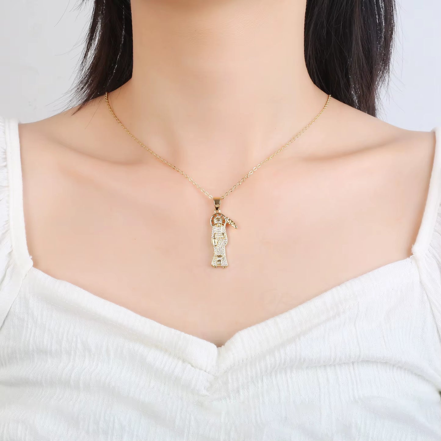 Woman wearing Santa Muerte Bust-Down Piece & Chain Necklace by Protect Ya Neck Designer Jewelry Pieces, draped over clavicle showing the necklace being worn and drop fit.