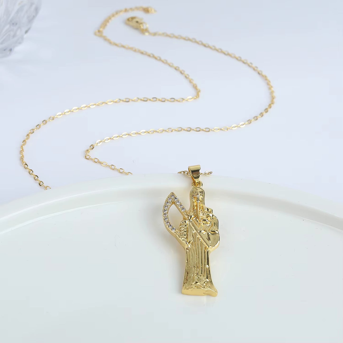 Image of Santa Muerte Bust-Down Piece & Chain Necklace by Protect Ya Neck Designer Jewelry Pieces design gold color plated copper option, with chain, over a white background.