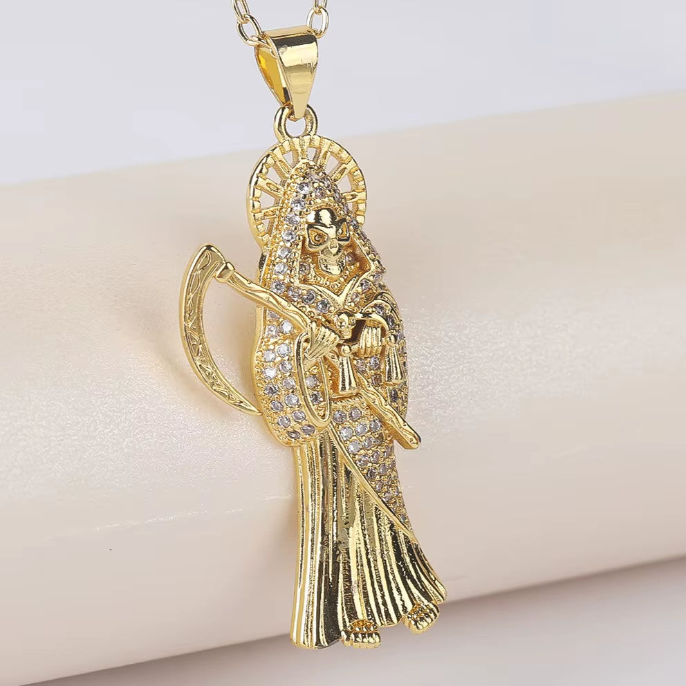 A gold-plated color copper pendant in the shape of Santa Muerte holding a scythe, with cubic zirconia accents, on an adjustable chain.