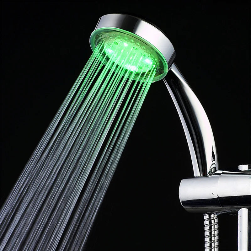 Chrome shower head with green LED light on a black background