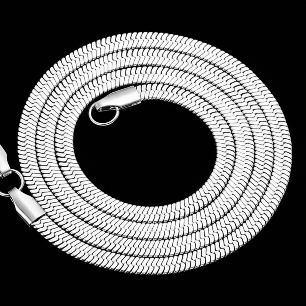 A coiled silver snake flat herringbone chain necklace with a lobster clasp, shown against a solid black background.