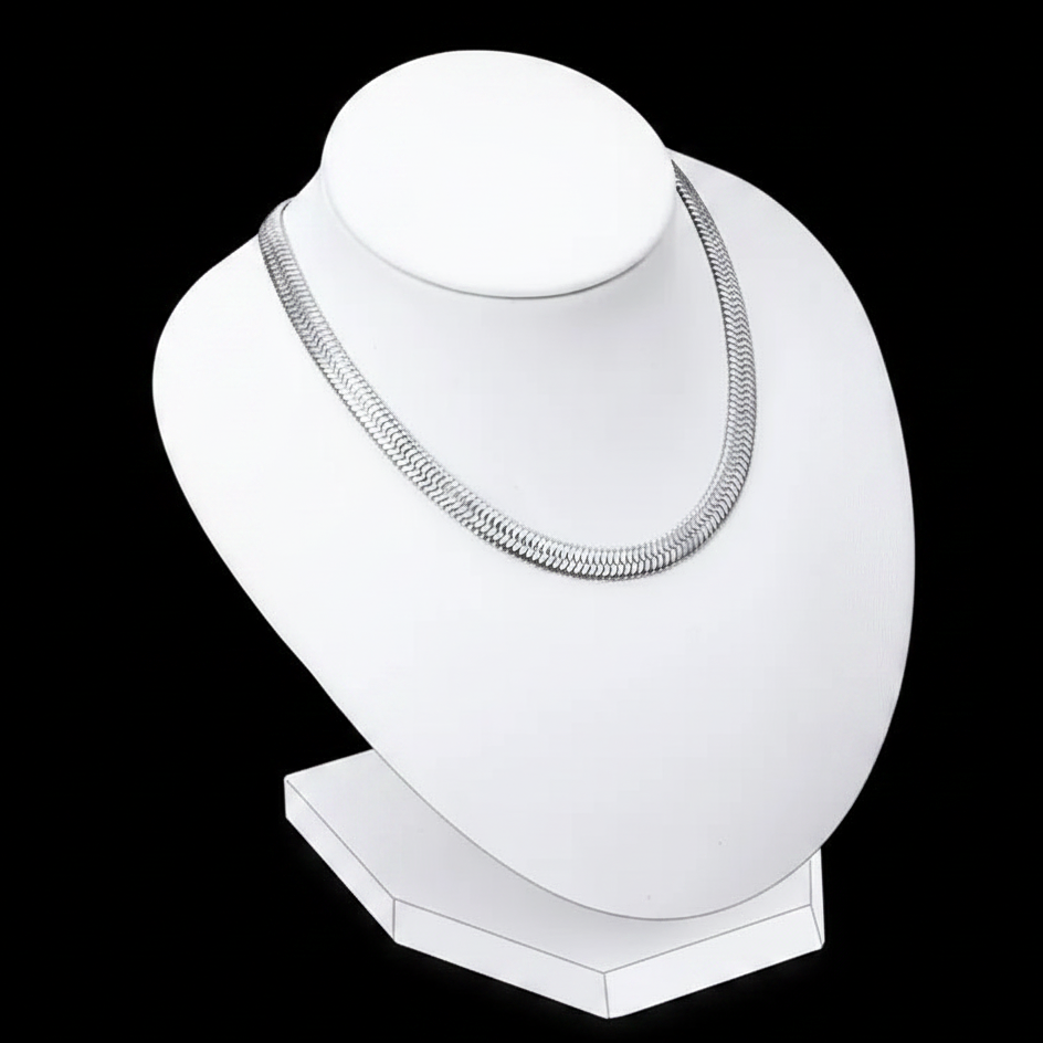A silver-toned herringbone snake chain necklace displayed on a white jewelry bust against a solid black background.