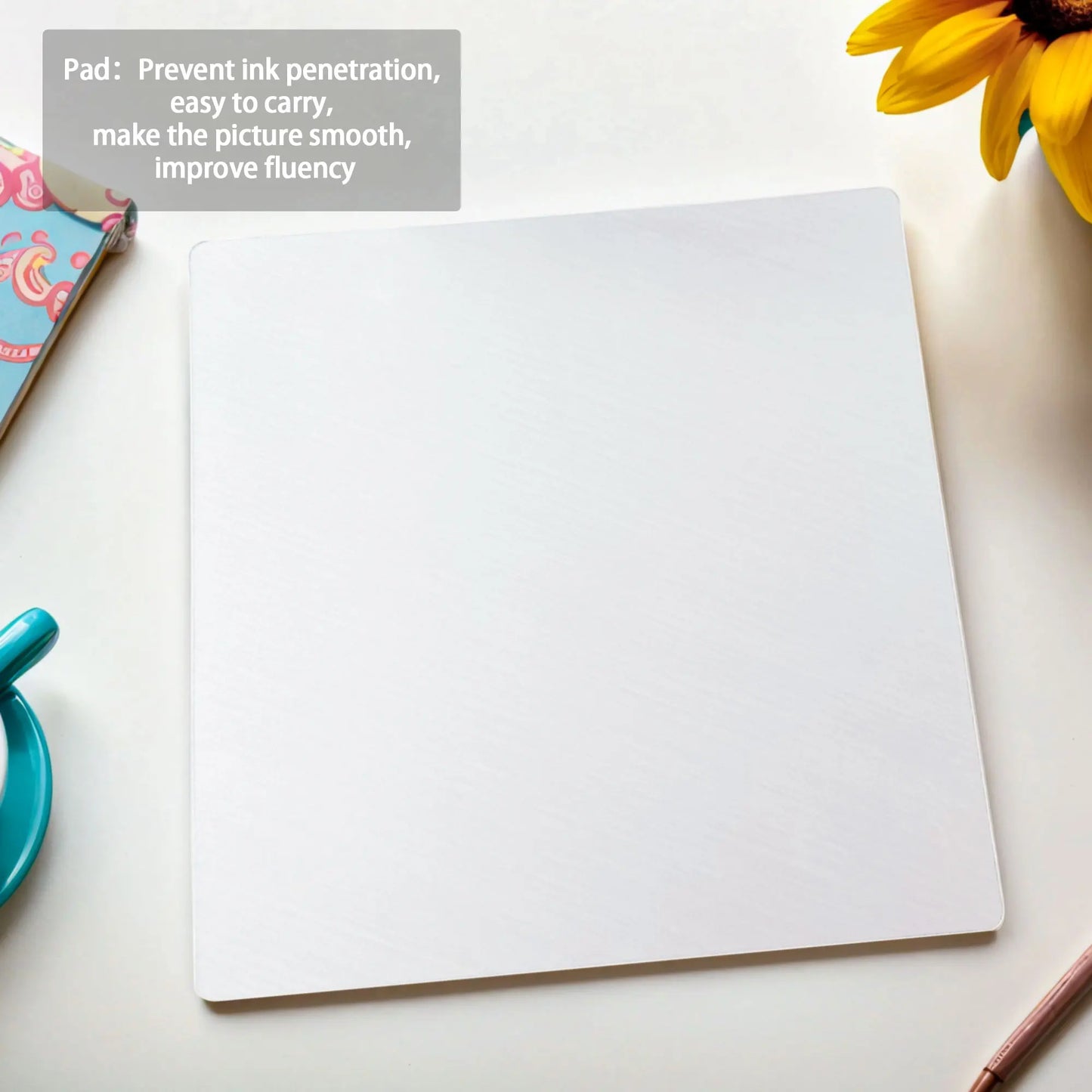 Blank sheet of paper on a white surface with a sunflower and stationery items.