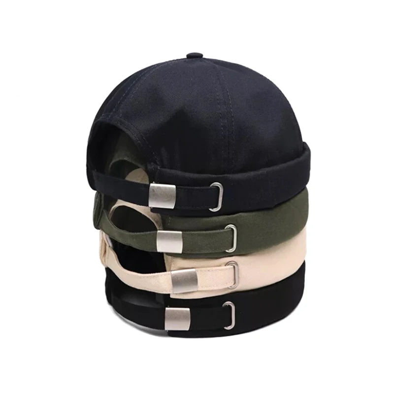 Stack of black, green, and white baseball caps with metal buckle snapback adjustable size slides on a white background